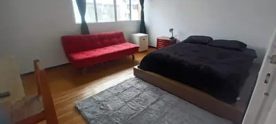 a bedroom with a red bed and a red chair at habitaciones amobladas la estrella in Manizales