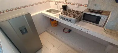 a small kitchen with a stove and a microwave at habitaciones amobladas la estrella in Manizales
