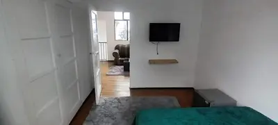 a room with a bed and a television on a wall at habitaciones amobladas la estrella in Manizales