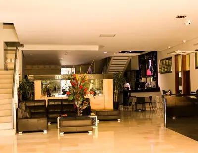 a lobby with a couch and a table in a building at Hotel Dorado La 70 in Medellín