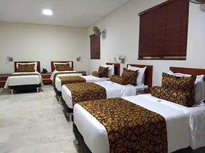 a hotel room with four beds and a couch at Hotel Dorado La 70 in Medellín
