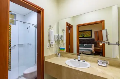 a bathroom with a sink and a shower and a mirror at Hotel Dorado La 70 in Medellín