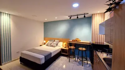 a small bedroom with a bed and a kitchen at 44-20 Tiny Loft in Medellín