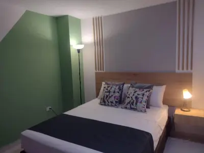 a bedroom with a bed with a green wall at 44-20 Tiny Loft in Medellín