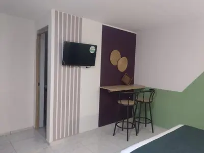 a small room with a table and a tv on the wall at 44-20 Tiny Loft in Medellín