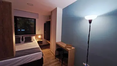 a bedroom with a bed and a lamp in a room at 44-20 Tiny Loft in Medellín
