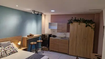 a bedroom with a bed and a kitchen with a sink at 44-20 Tiny Loft in Medellín