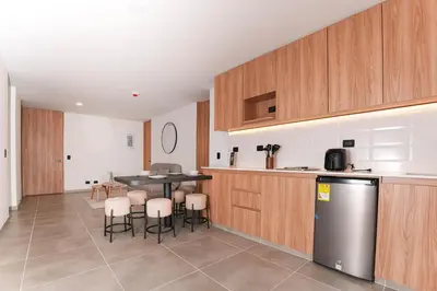 a kitchen with a table and chairs and a counter at Metropolitan Living by HOUSY in Medellín