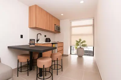 a kitchen with a black counter and stools at Metropolitan Living by HOUSY in Medellín
