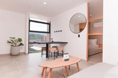 a dining room and living room with a table and a mirror at Metropolitan Living by HOUSY in Medellín