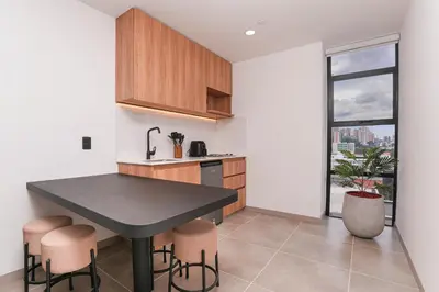 a kitchen with a black table and stools at Metropolitan Living by HOUSY in Medellín