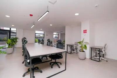an office with desks and chairs and plants at Metropolitan Living by HOUSY in Medellín