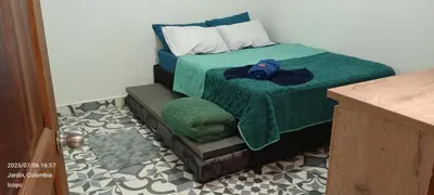 a bedroom with a bed with a green comforter at Apartamento completo in Jardin