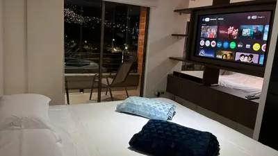 a bedroom with a bed with a flat screen tv at Mirador pueblito Paisa-Tipo loft in Medellín