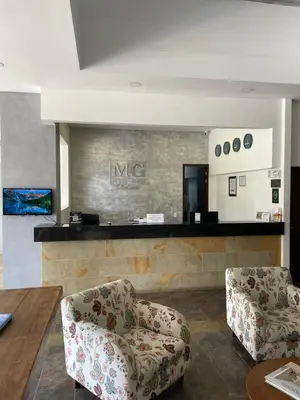 a living room with two chairs and a counter at Suite Casa Grande in Rionegro