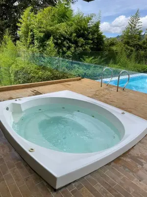 a bath tub sitting on a patio next to a pool at Suite Casa Grande in Rionegro
