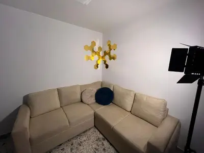 a living room with a couch and a flower on the wall at Amplio apartamento Guayabal cerca aeropuerto Olaya Herrera in Medellín