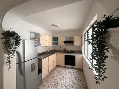 a kitchen with white cabinets and a refrigerator at Amplio apartamento Guayabal cerca aeropuerto Olaya Herrera in Medellín