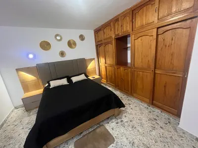 a bedroom with a bed and wooden cabinets at Amplio apartamento Guayabal cerca aeropuerto Olaya Herrera in Medellín