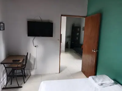 a room with a bed and a television on the wall at Casa Campestre en Guarne in Guarne