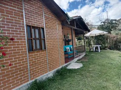 a brick house with a table and an umbrella at Casa Campestre en Guarne in Guarne