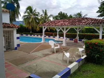two chairs and a gazebo next to a pool at Casa campestre con piscina, jacuzzi y bbq in La Dorada