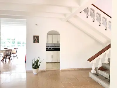 a white living room with stairs and a table at Casa campestre con piscina, jacuzzi y bbq in La Dorada
