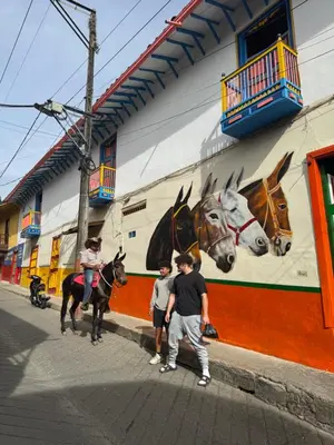 a group of people standing in front of a mural of horses at Finca turística Villa Carolina in Sabaletas