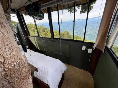 a bedroom with a bed in a tree house at Finca turística Villa Carolina in Sabaletas