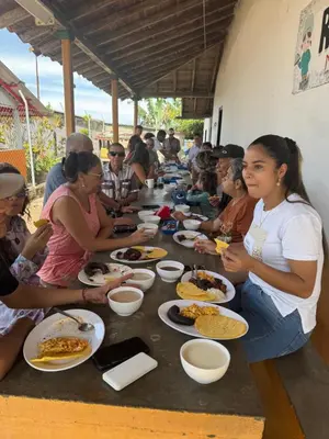 a group of people sitting around a long table eating food at Finca turística Villa Carolina in Sabaletas