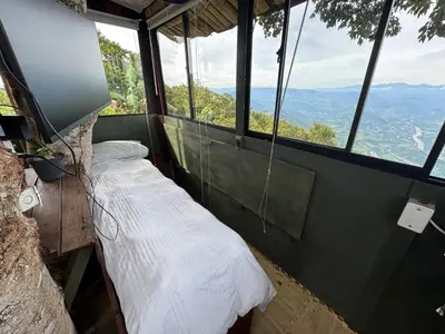 a bed in a room with a view of the mountains at Finca turística Villa Carolina in Sabaletas