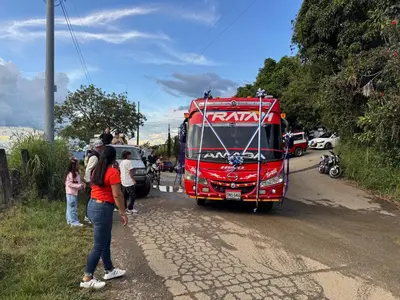 a group of people standing next to a red bus at Finca turística Villa Carolina in Sabaletas