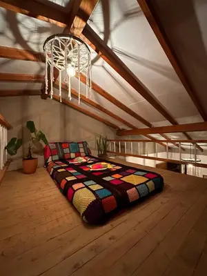 a bed sitting on a wooden floor in a room at Mamaquilla Grupal Glamping in Jardin