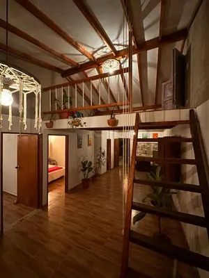 a living room with a staircase and a room with a stair case at Mamaquilla Grupal Glamping in Jardin
