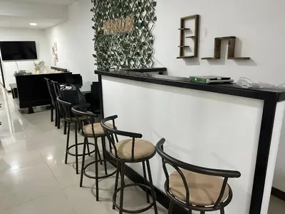 a bar with black stools in a room with a hair salon at 9 Bedrooms house in Medellín