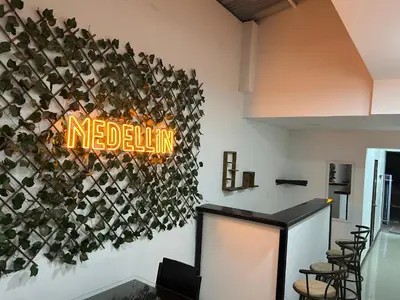 a restaurant with a neon sign on the wall at 9 Bedrooms house in Medellín