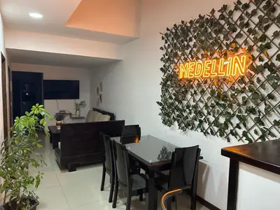a restaurant with a table and a sign on the wall at 9 Bedrooms house in Medellín