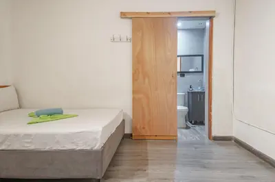 a small bedroom with a bed and a bathroom at Hostal Machu Picchu Medellín in Medellín