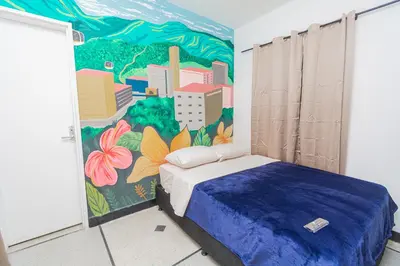 a bedroom with a mural of a city at Hostal Bendito, central y cómodo in Medellín