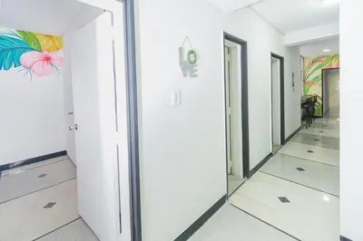 a hallway with white walls and colorful paintings on the walls at Hostal Bendito, central y cómodo in Medellín