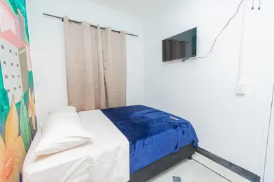a bedroom with a bed and a tv on a wall at Hostal Bendito, central y cómodo in Medellín
