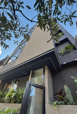a house with a black roof and a window at Autenthico Local Stay Hotel Envigado in Envigado