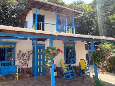 a house with blue and yellow chairs in front of it at El Refugio in Copacabana