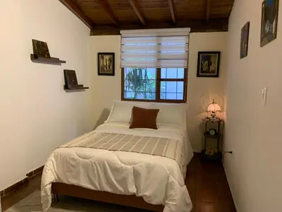 a bedroom with a bed and a window at El Solar Hostel - Comuna 13, graffitour in Medellín