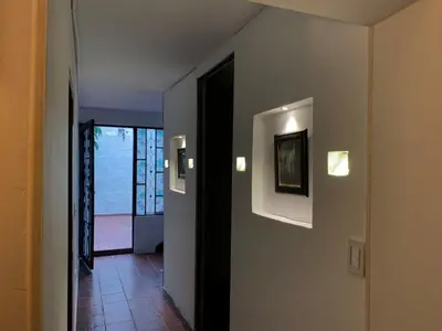 a hallway with two lights on a wall with a door at El Solar Hostel - Comuna 13, graffitour in Medellín