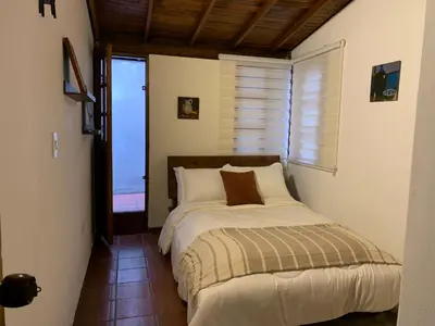 a bedroom with a bed and a window at El Solar Hostel - Comuna 13, graffitour in Medellín
