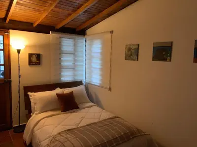 a bedroom with a bed with a window and a lamp at El Solar Hostel - Comuna 13, graffitour in Medellín