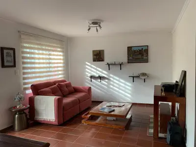 a living room with a red couch and a table at El Solar Hostel - Comuna 13, graffitour in Medellín