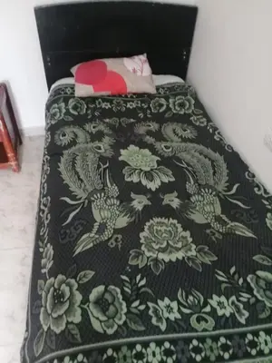 a bed with a black and green blanket on it at Delicias del rio in San Rafael