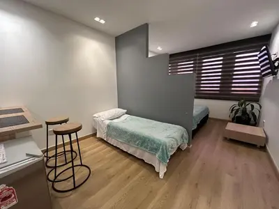 a bedroom with a bed and two stools in it at Elegante lugar a pasos del metro in Medellín